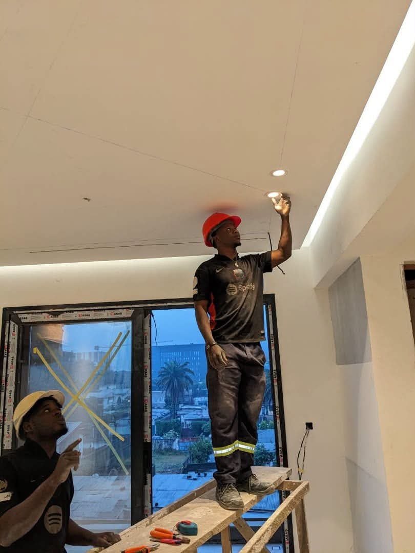 Technicien posant un spot LED encastré en faux plafond