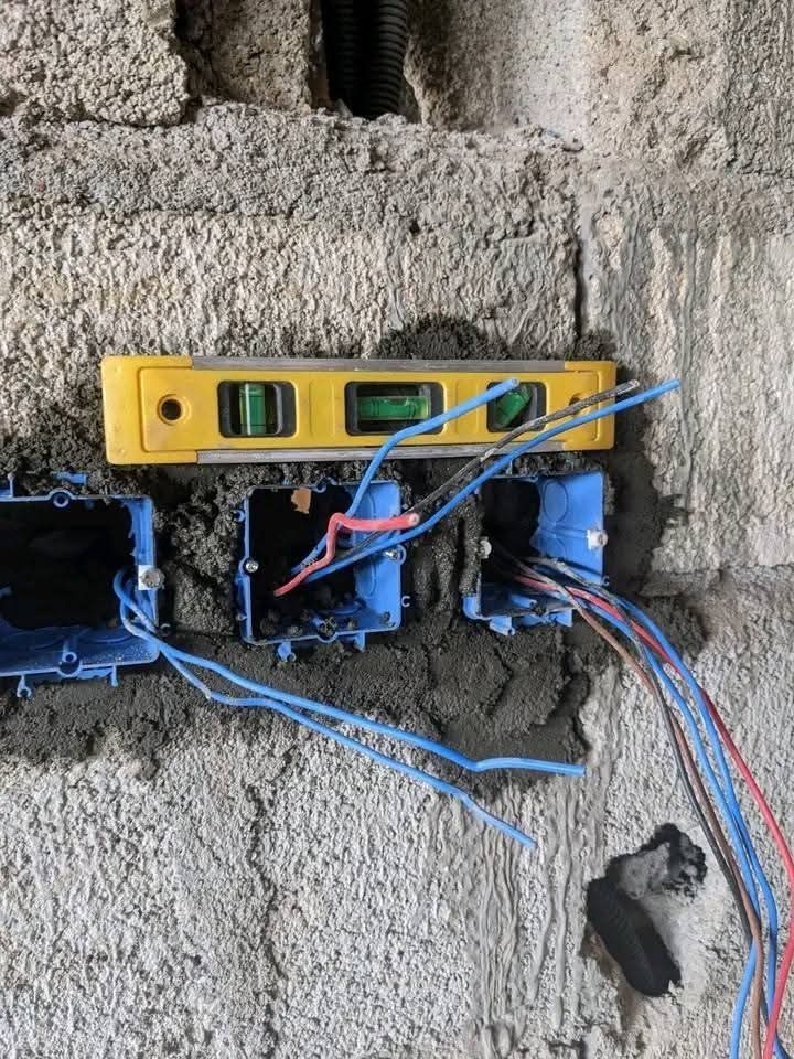 Boîtiers d'encastrement électriques alignés au niveau à bulle avant câblage