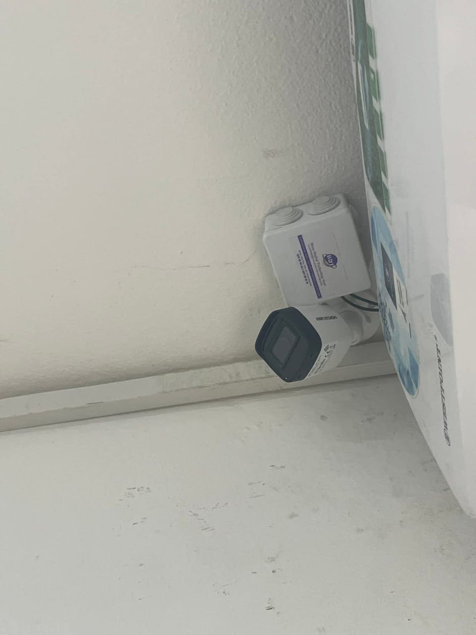 Caméra de surveillance raccordée à un boîtier de dérivation en angle de mur