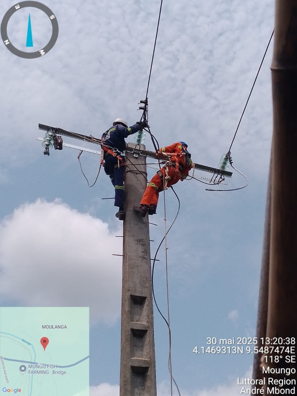 Deux techniciens harnachés en intervention sur un poteau électrique en zone rurale