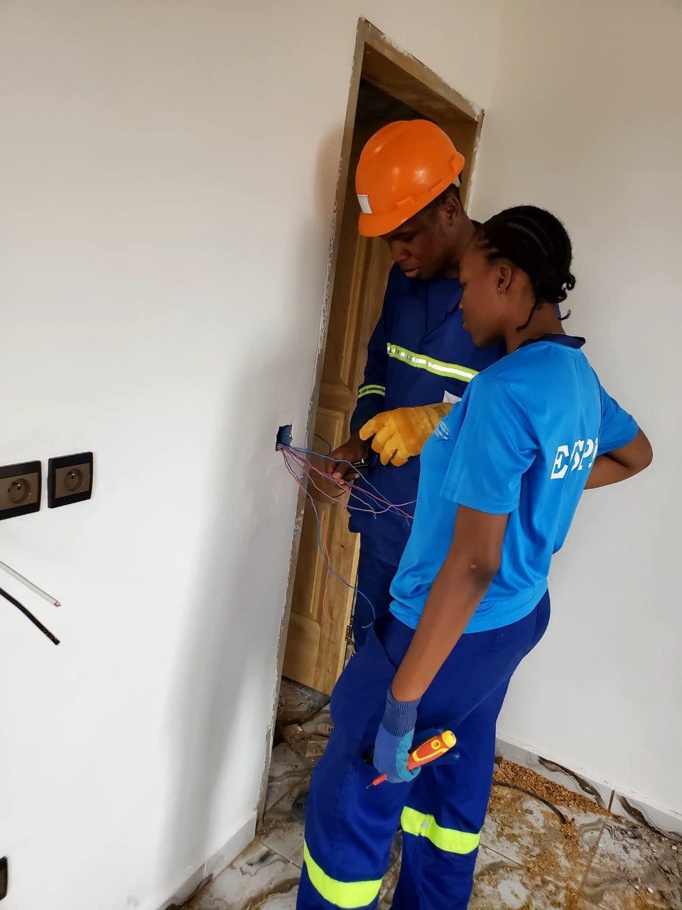 Deux techniciens raccordant une prise murale électrique