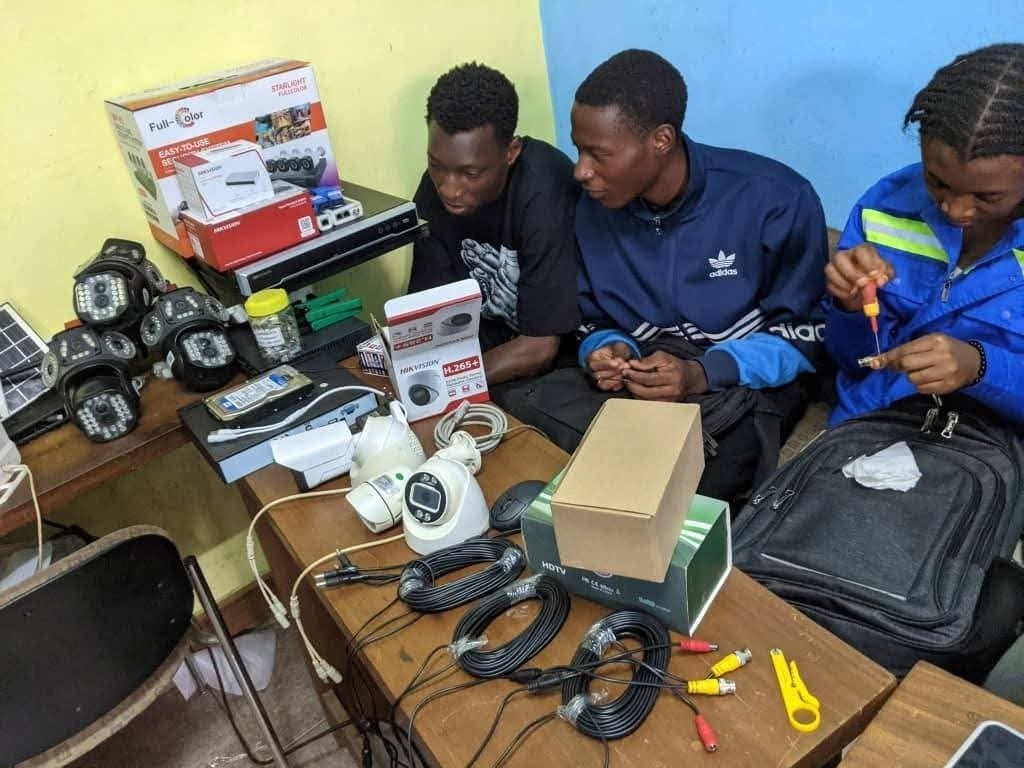 Équipe technique préparant du matériel de vidéosurveillance en atelier