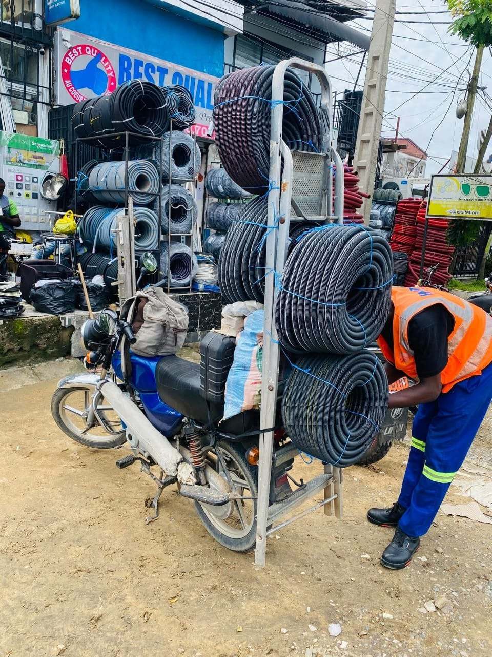 Technicien chargeant des rouleaux de gaines électriques pour livraison sur chantier
