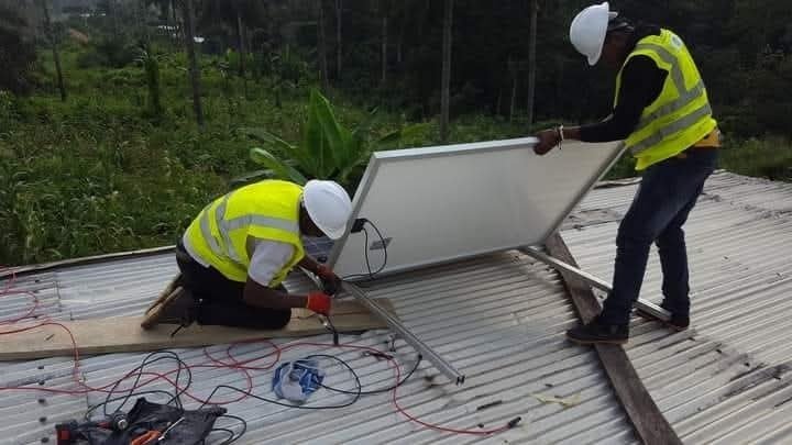 Techniciens raccordant un panneau solaire sur une toiture métallique